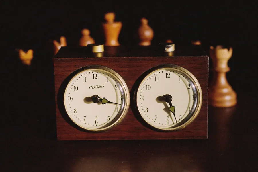 Gros plan sur une pendule d'échecs mécanique en bois et laiton